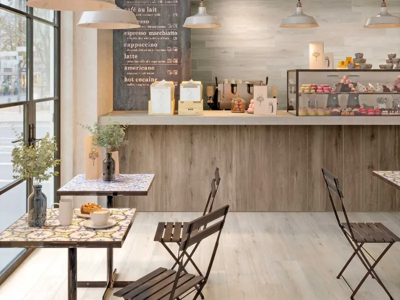 Open kitchen in a café with a light Italian porcelain stoneware floor